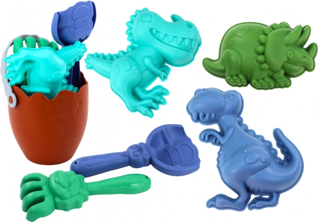 Set de nisip dinozauri cu găleată în formă de ou, lopățică, greblă și forme