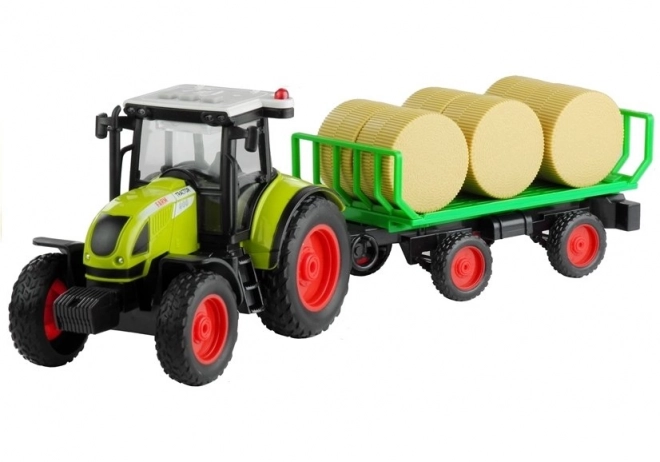 Tractor verde cu remorcă și baloturi de fân