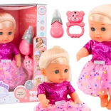 Păpușă în rochiță roz cu biberon și zornăitoare, cu sunete și funcție de făcut pipi